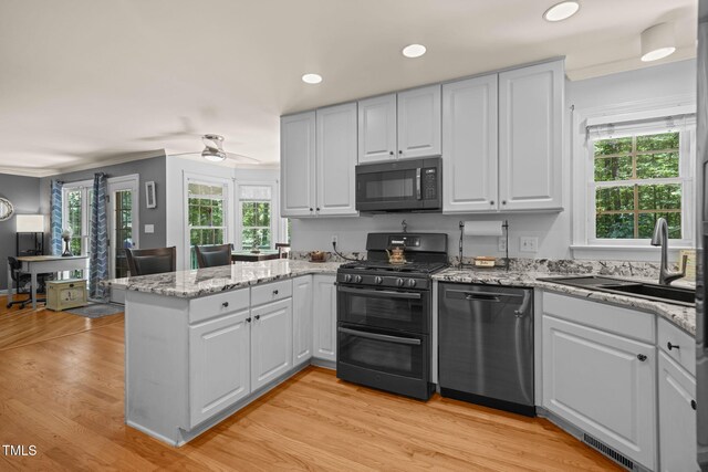 2401 Worthing Ct, Wake Forest, NC 27587 - kitchen with black appliances, a peninsula, ceiling fan, recessed lighting, and plenty of natural light