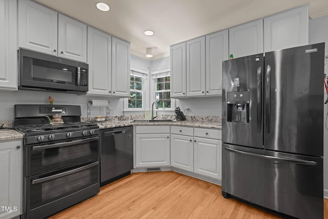 2401 Worthing Ct, Wake Forest, NC 27587 - kitchen featuring refrigerator with ice dispenser, dishwashing machine, range with two ovens, light wood-type flooring, and light stone countertops