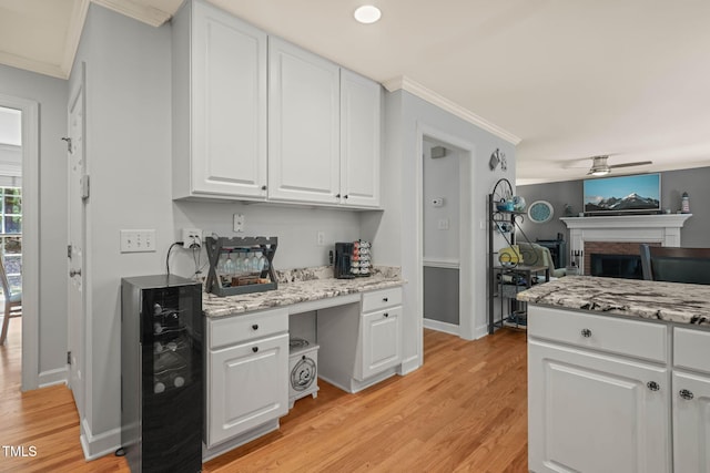 2401 Worthing Ct, Wake Forest, NC 27587 - kitchen featuring light wood finished floors, ornamental molding, white cabinets, wine cooler, and a ceiling fan