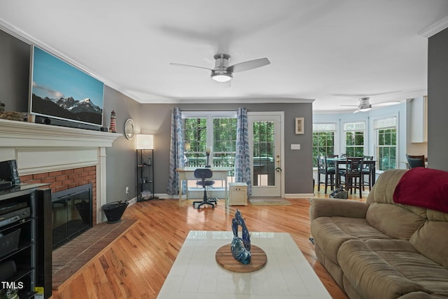 2401 Worthing Ct, Wake Forest, NC 27587 - living room featuring a ceiling fan, crown molding, a brick fireplace, and wood finished floors