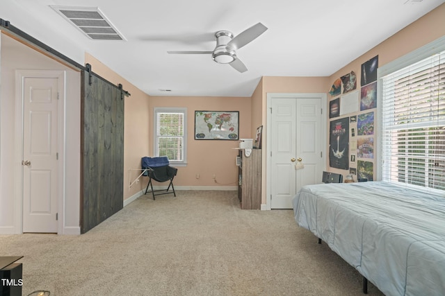 2401 Worthing Ct, Wake Forest, NC 27587 - carpeted bedroom with a barn door, a ceiling fan, and a closet