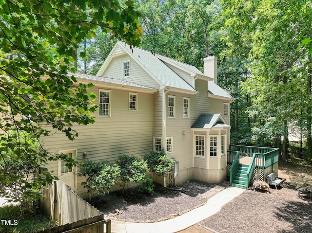 2401 Worthing Ct, Wake Forest, NC 27587 - back of property featuring a wooden deck, a shingled roof, and a chimney