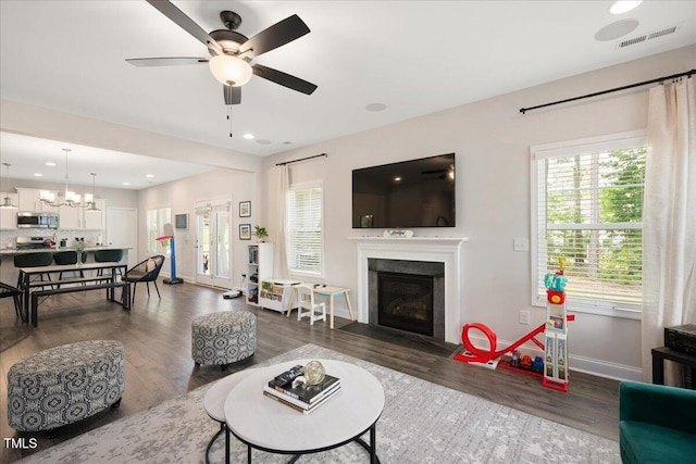 103 Foothill Ct, Sanford, NC 27330 - living area featuring dark wood-type flooring, a glass covered fireplace, a ceiling fan, recessed lighting, and a chandelier