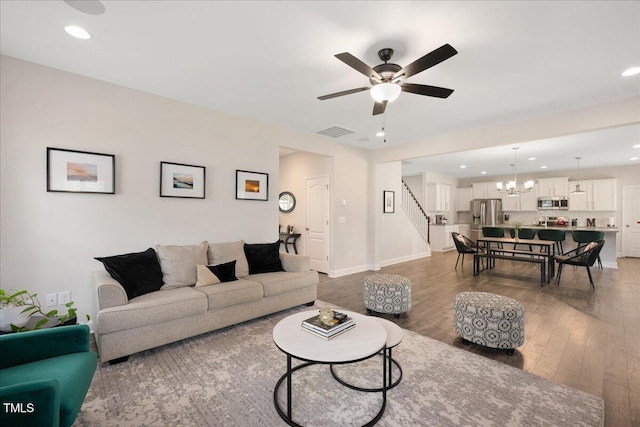 103 Foothill Ct, Sanford, NC 27330 - living room with stairs, wood finished floors, recessed lighting, ceiling fan, and a chandelier