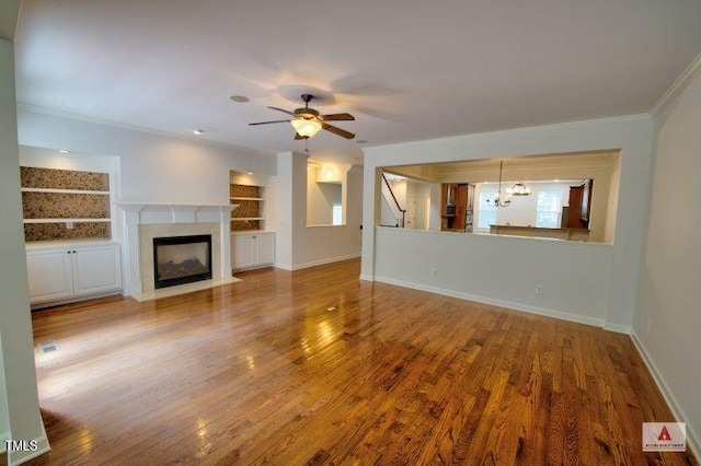 332 Bridgegate Dr, Cary, NC 27519 - unfurnished living room featuring crown molding, wood finished floors, a high end fireplace, ceiling fan, and a chandelier
