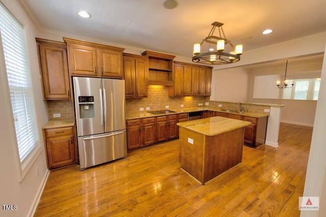332 Bridgegate Dr, Cary, NC 27519 - kitchen with stainless steel appliances, a chandelier, a peninsula, brown cabinets, and ornamental molding