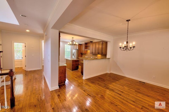 332 Bridgegate Dr, Cary, NC 27519 - kitchen with a chandelier, brown cabinetry, open shelves, refrigerator with ice dispenser, and ornamental molding