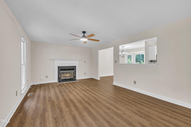 4309 Birmingham Way, Raleigh, NC 27604 - unfurnished living room featuring ceiling fan, wood finished floors, a chandelier, and a fireplace with raised hearth