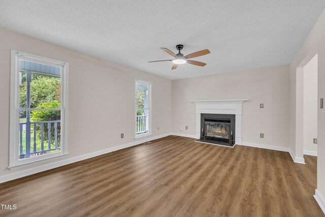 4309 Birmingham Way, Raleigh, NC 27604 - unfurnished living room with ceiling fan, wood finished floors, a fireplace with raised hearth, and a textured ceiling