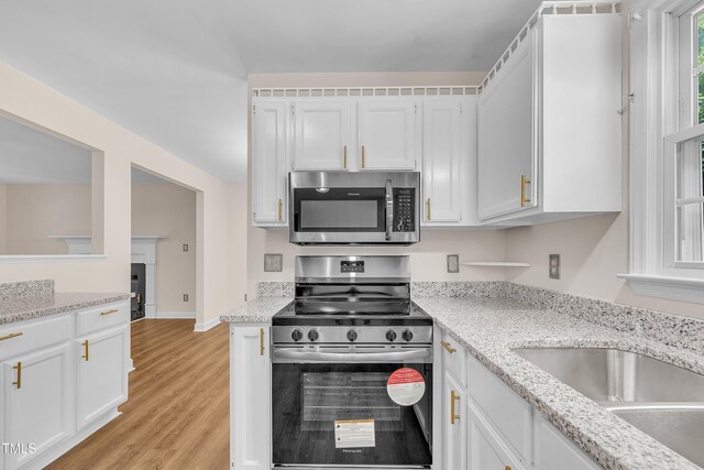 4309 Birmingham Way, Raleigh, NC 27604 - kitchen with stainless steel appliances, white cabinetry, light wood-style floors, and light stone counters