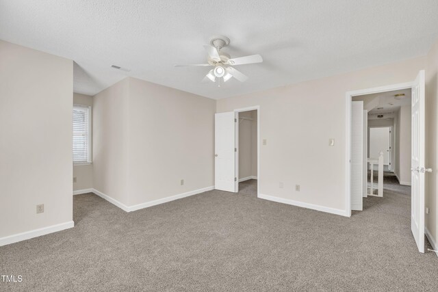 4309 Birmingham Way, Raleigh, NC 27604 - unfurnished bedroom featuring carpet, a walk in closet, a textured ceiling, and a ceiling fan