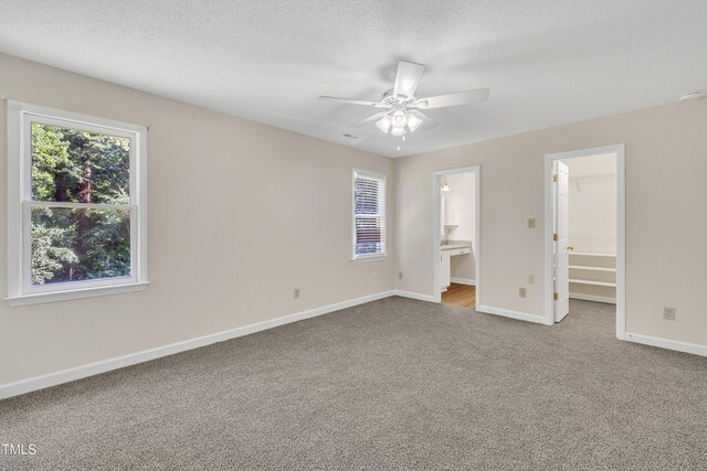 4309 Birmingham Way, Raleigh, NC 27604 - unfurnished bedroom featuring carpet, a spacious closet, ensuite bathroom, a ceiling fan, and a textured ceiling