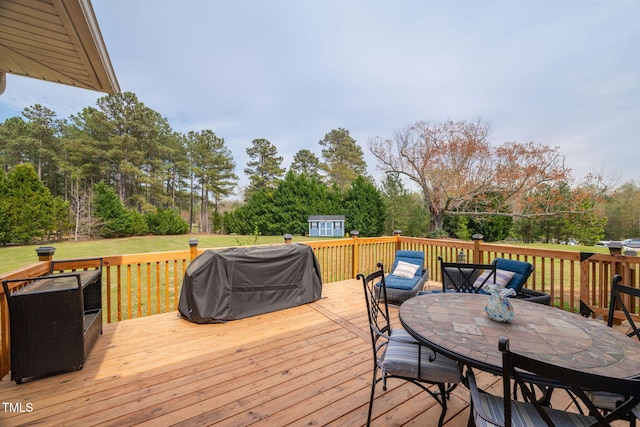 169 Skippers Lndg, Manson, NC 27553 - wooden terrace with grilling area, outdoor dining area, a storage shed, and view of scattered trees