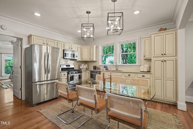 211 W Trinity Ave, Durham, NC 27701 - kitchen featuring cream cabinets, stainless steel appliances, crown molding, backsplash, and a chandelier