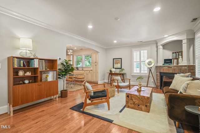 211 W Trinity Ave, Durham, NC 27701 - living room with recessed lighting, light wood-type flooring, arched walkways, ornamental molding, and a fireplace