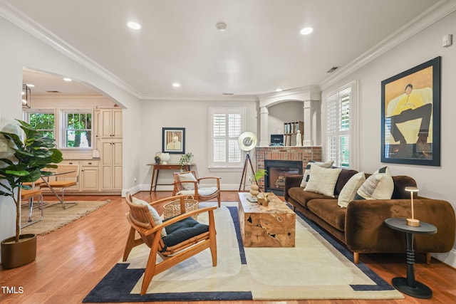 211 W Trinity Ave, Durham, NC 27701 - living area with ornamental molding, light wood-style flooring, a fireplace, recessed lighting, and arched walkways