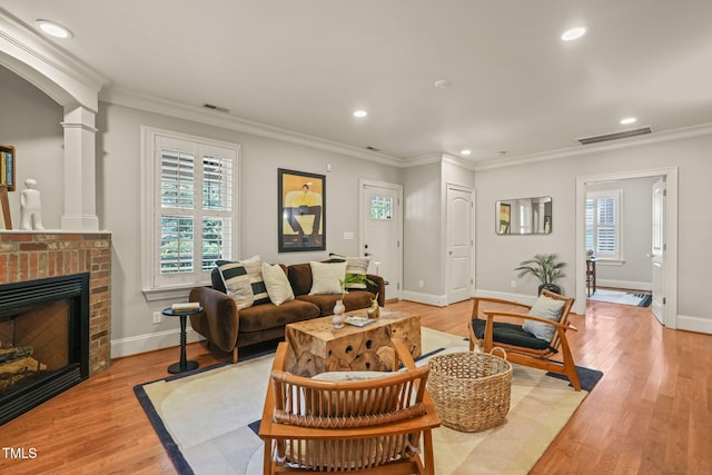 211 W Trinity Ave, Durham, NC 27701 - living room with light wood-style flooring, recessed lighting, a brick fireplace, ornate columns, and ornamental molding