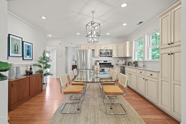 211 W Trinity Ave, Durham, NC 27701 - dining area featuring crown molding, light wood finished floors, a chandelier, and recessed lighting