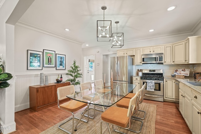 211 W Trinity Ave, Durham, NC 27701 - dining room featuring a chandelier, ornamental molding, light wood-type flooring, recessed lighting, and wainscoting