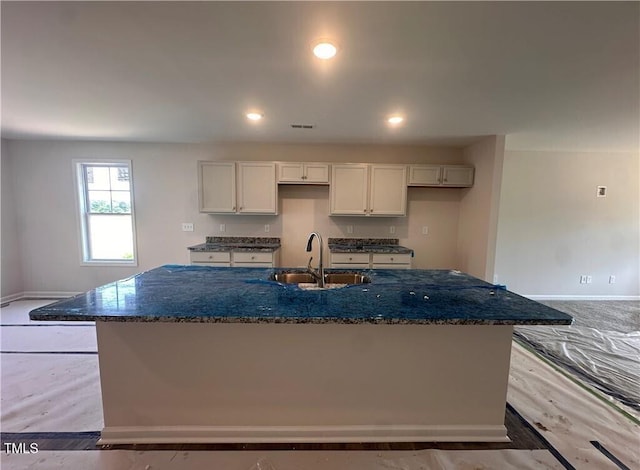112 Dalton Dr, Lumber Bridge, NC 28357 - kitchen featuring a center island with sink, dark stone countertops, recessed lighting, light wood-style floors, and white cabinets