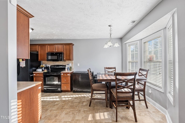 205 Driftwood Ln, Raeford, NC 28376 - dining room featuring healthy amount of natural light, a textured ceiling, and a chandelier