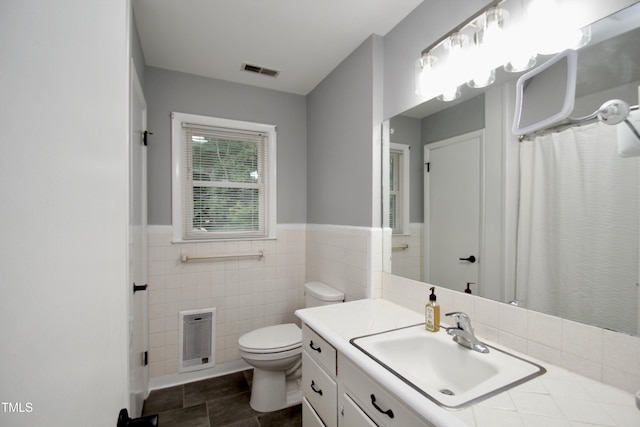 3812 Vesta Dr, Raleigh, NC 27603 - bathroom with vanity, tile walls, wainscoting, heating unit, and curtained shower