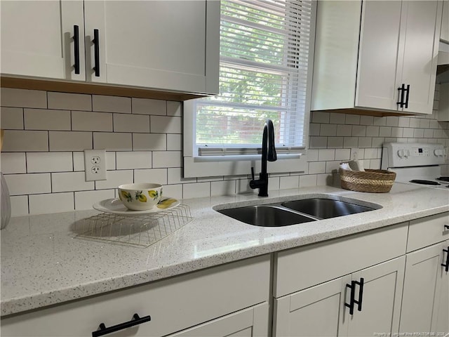 3513 Greenwood Dr, Fayetteville, NC 28311 - kitchen with white cabinets, decorative backsplash, light stone countertops, and white range with electric cooktop