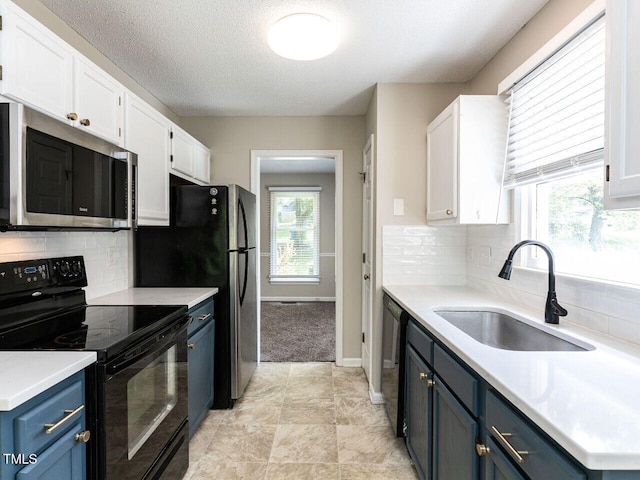 23 Joci Ct, Durham, NC 27704 - kitchen featuring stainless steel microwave, black electric range, blue cabinets, white cabinets, and light countertops