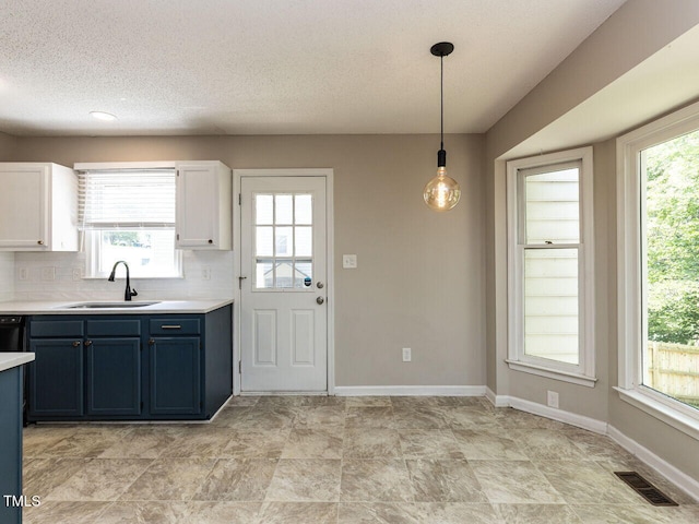 23 Joci Ct, Durham, NC 27704 - kitchen with light countertops, blue cabinetry, hanging light fixtures, white cabinets, and a textured ceiling