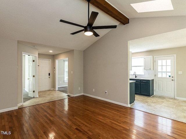 23 Joci Ct, Durham, NC 27704 - unfurnished living room featuring a skylight, light wood-style flooring, and a ceiling fan