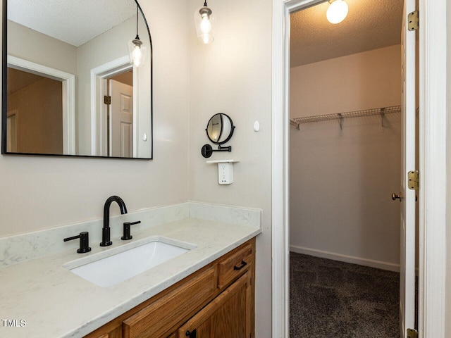 23 Joci Ct, Durham, NC 27704 - bathroom with vanity, a textured ceiling, and a spacious closet