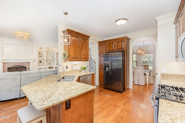 114 Boone Trl, Garner, NC 27529 - kitchen with stainless steel appliances, arched walkways, a peninsula, light wood-style flooring, and light stone countertops