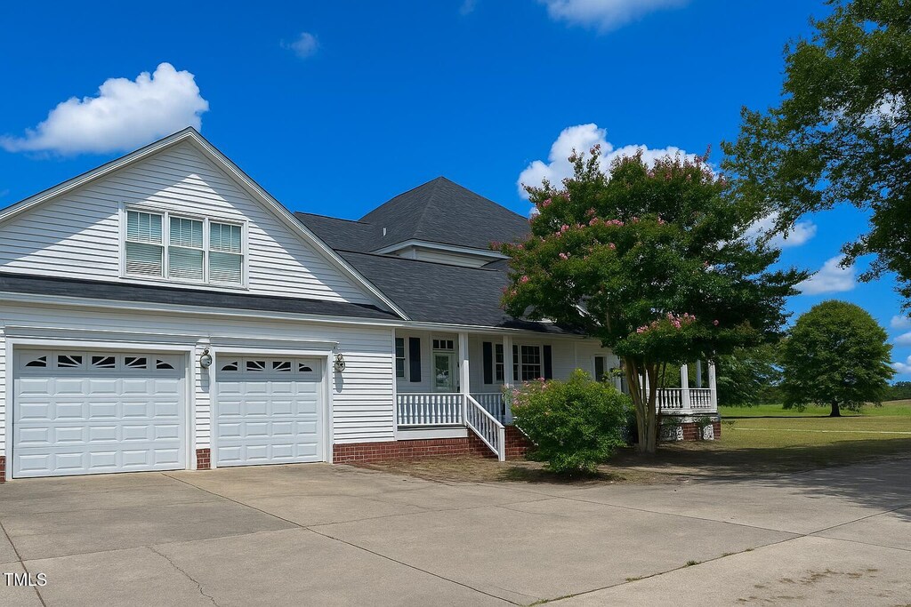 1768 Greens Bridge Rd, Garland, NC 28441 - traditional home with covered porch, driveway, an attached garage, and roof with shingles