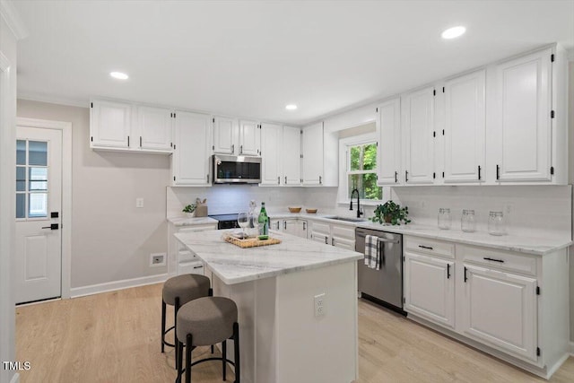 4006 New Yarmouth Way, Apex, NC 27502 - kitchen with stainless steel appliances, white cabinets, light wood-type flooring, a kitchen island, and recessed lighting