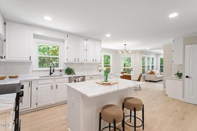 4006 New Yarmouth Way, Apex, NC 27502 - kitchen with light wood-style flooring, recessed lighting, backsplash, a breakfast bar area, and white cabinetry