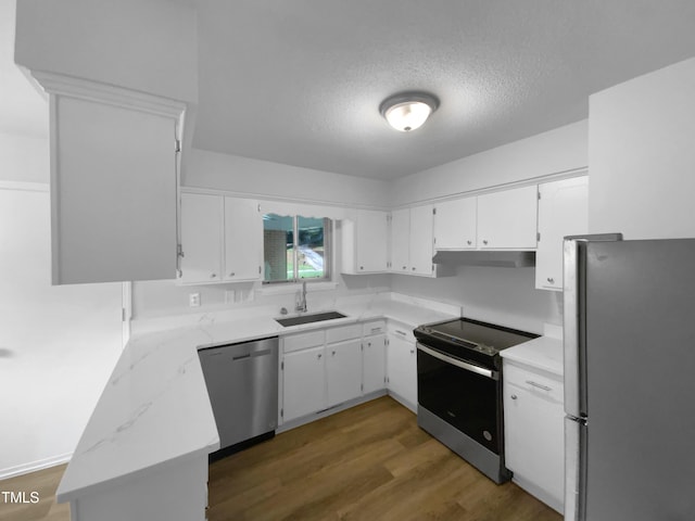 3721 Suffolk St, Durham, NC 27707 - kitchen featuring appliances with stainless steel finishes, under cabinet range hood, white cabinetry, a textured ceiling, and dark wood-style flooring