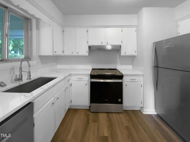 3721 Suffolk St, Durham, NC 27707 - kitchen featuring stainless steel appliances, under cabinet range hood, dark wood-style floors, white cabinetry, and light stone countertops