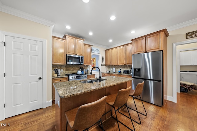 2027 River Grove Ln, Knightdale, NC 27545 - kitchen with appliances with stainless steel finishes, ornamental molding, light wood-type flooring, light stone countertops, and tasteful backsplash