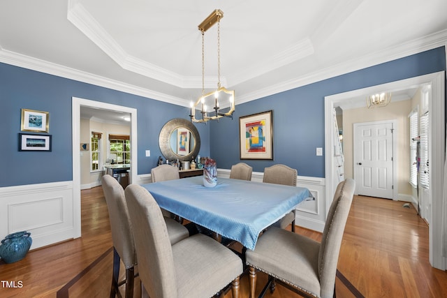 2027 River Grove Ln, Knightdale, NC 27545 - dining room featuring a chandelier, ornamental molding, a raised ceiling, wood finished floors, and wainscoting