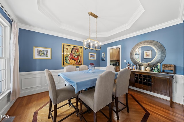 2027 River Grove Ln, Knightdale, NC 27545 - dining room with a chandelier, wood finished floors, a tray ceiling, crown molding, and wainscoting