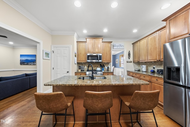 2027 River Grove Ln, Knightdale, NC 27545 - kitchen featuring stainless steel appliances, light stone counters, ornamental molding, a kitchen breakfast bar, and tasteful backsplash
