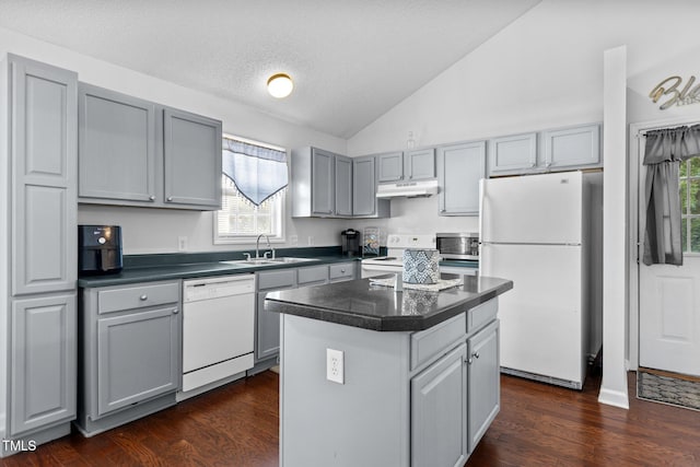 4505 Woodlawn Dr, Raleigh, NC 27616 - kitchen featuring white appliances, gray cabinetry, under cabinet range hood, dark countertops, and vaulted ceiling