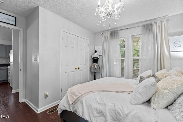 4505 Woodlawn Dr, Raleigh, NC 27616 - bedroom featuring dark wood-type flooring, a closet, a textured ceiling, and a chandelier