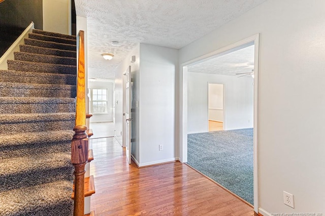 5228 Wallbrook Dr, Fayetteville, NC 28306 - stairway with wood finished floors, a textured ceiling, and a ceiling fan
