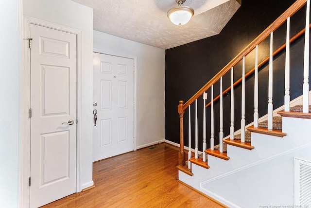 5228 Wallbrook Dr, Fayetteville, NC 28306 - entrance foyer with wood finished floors, stairs, and a textured ceiling