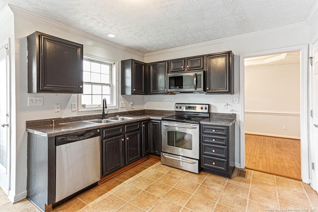 5228 Wallbrook Dr, Fayetteville, NC 28306 - kitchen with stainless steel appliances, dark countertops, a textured ceiling, ornamental molding, and recessed lighting