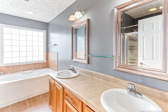 5228 Wallbrook Dr, Fayetteville, NC 28306 - bathroom with a bath, double vanity, tile patterned floors, a textured ceiling, and a shower with shower door