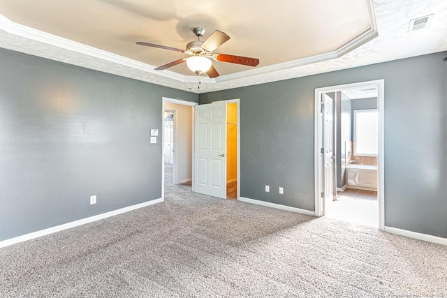 5228 Wallbrook Dr, Fayetteville, NC 28306 - unfurnished bedroom with crown molding, carpet flooring, a tray ceiling, a ceiling fan, and ensuite bathroom