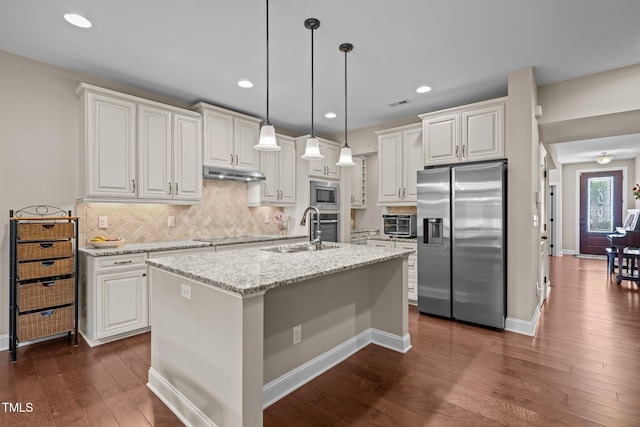 317 Striped Maple Ct, Apex, NC 27539 - kitchen featuring appliances with stainless steel finishes, under cabinet range hood, dark wood-type flooring, white cabinetry, and recessed lighting