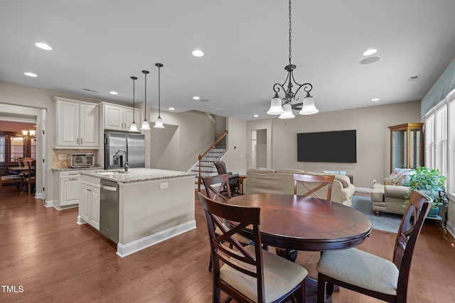 317 Striped Maple Ct, Apex, NC 27539 - dining area featuring stairs, wood finished floors, recessed lighting, and a chandelier